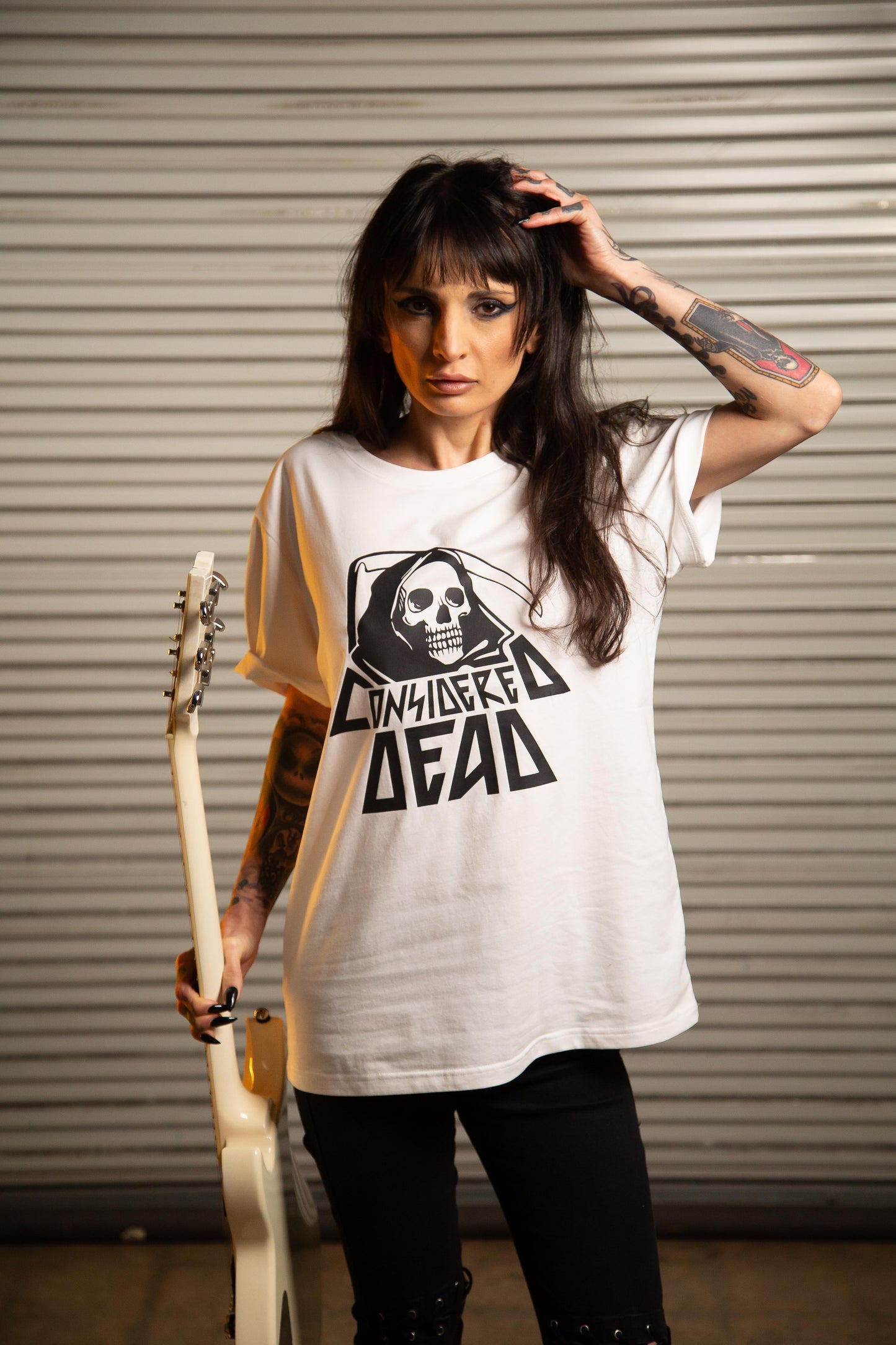Model wearing the white Considered Dead Reaper eco friendly tee at a skatepark in Dallas, Texas.
