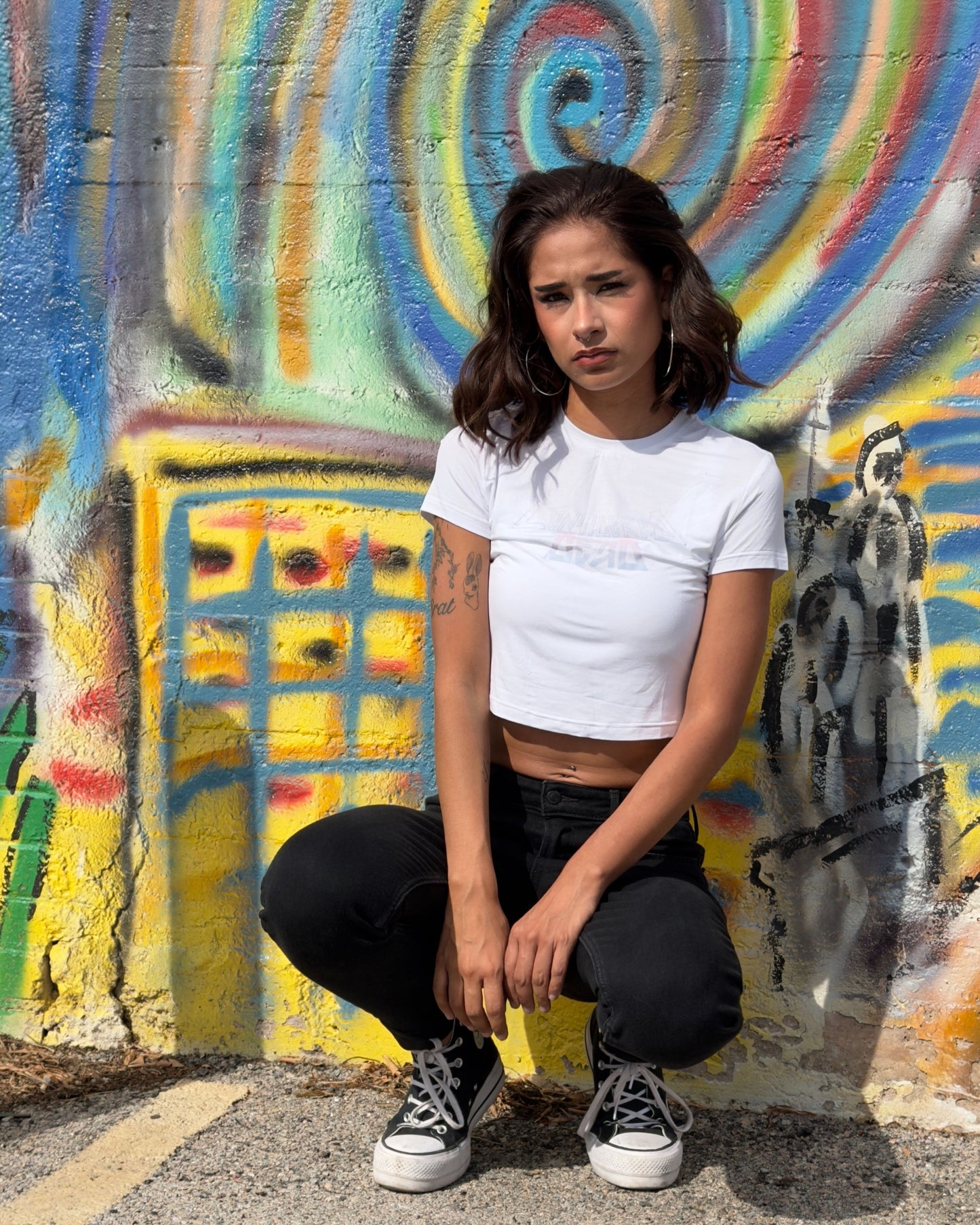 Model wearing a white sustainable crop tee with gradient text and high-waisted bottoms, showcasing the soft fabric drape.