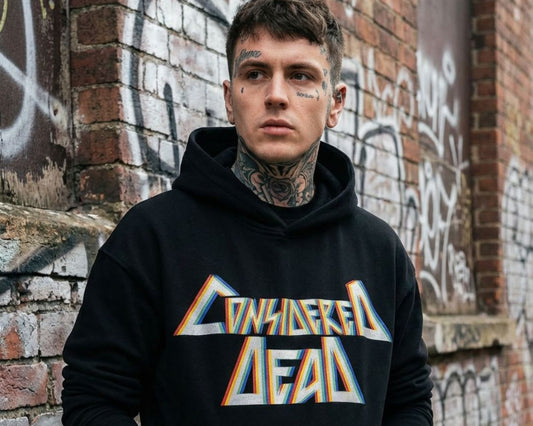 Man wearing a black hoodie with 'Considered Dead' text against a graffiti-covered wall.